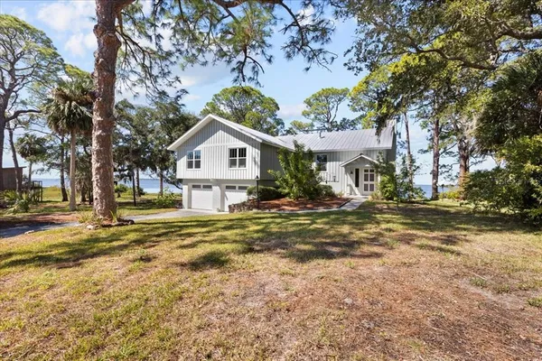 a view of a house with a large tree and a big yard