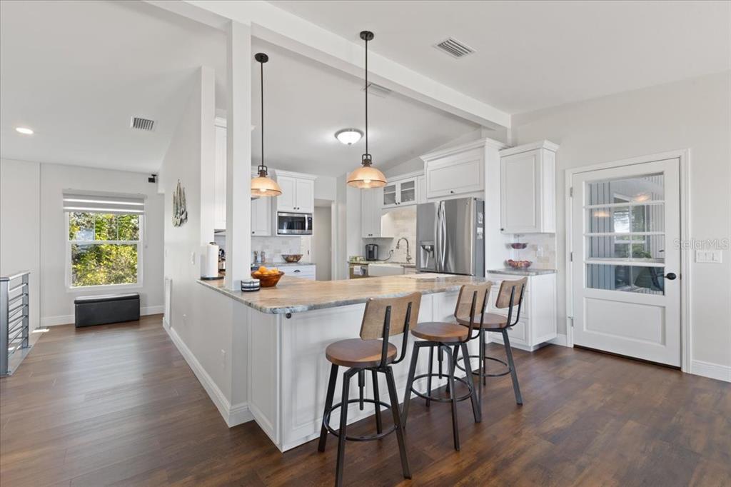 16931 Southwest 133 Street Cedar Key, FL 32625 - Photo 27 of 57 a kitchen that has a lot of cabinets a sink and wooden floor