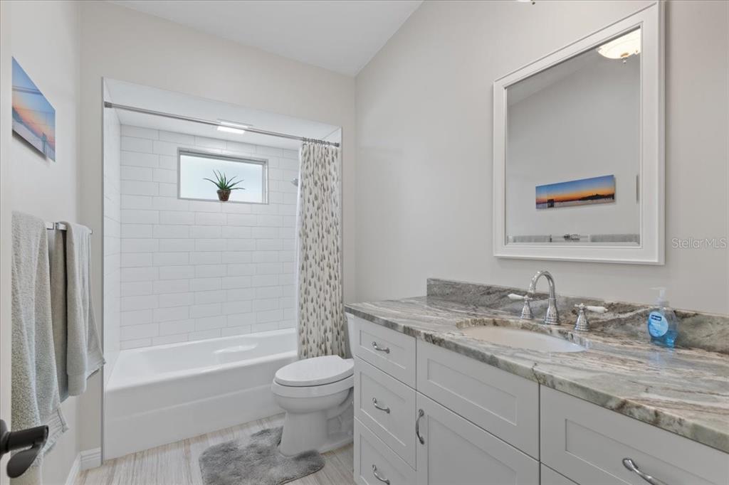 16931 Southwest 133 Street Cedar Key, FL 32625 - Photo 42 of 57 a bathroom with a granite countertop sink a toilet and shower