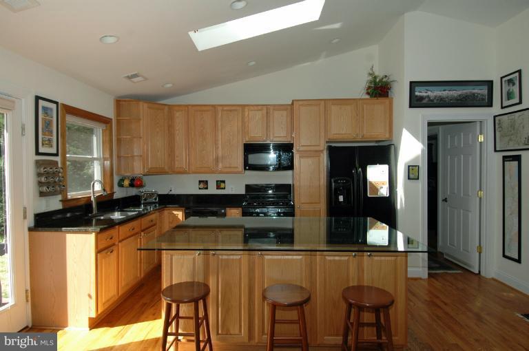 108 Farmington Road West Accokeek, MD 20607 - Photo 4 of 30 a kitchen with granite countertop a stove a sink a microwave and cabinets