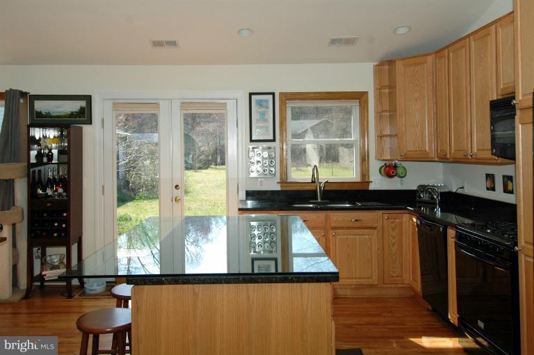 108 Farmington Road West Accokeek, MD 20607 - Photo 5 of 30 a kitchen with stainless steel appliances granite countertop a stove a sink and a microwave