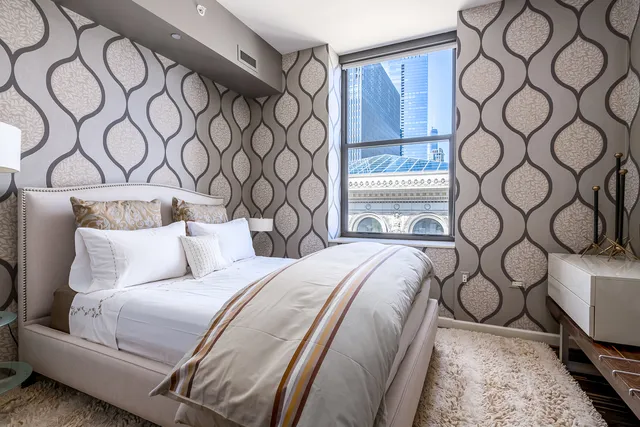 a bedroom with a bed and wall painting on the wall