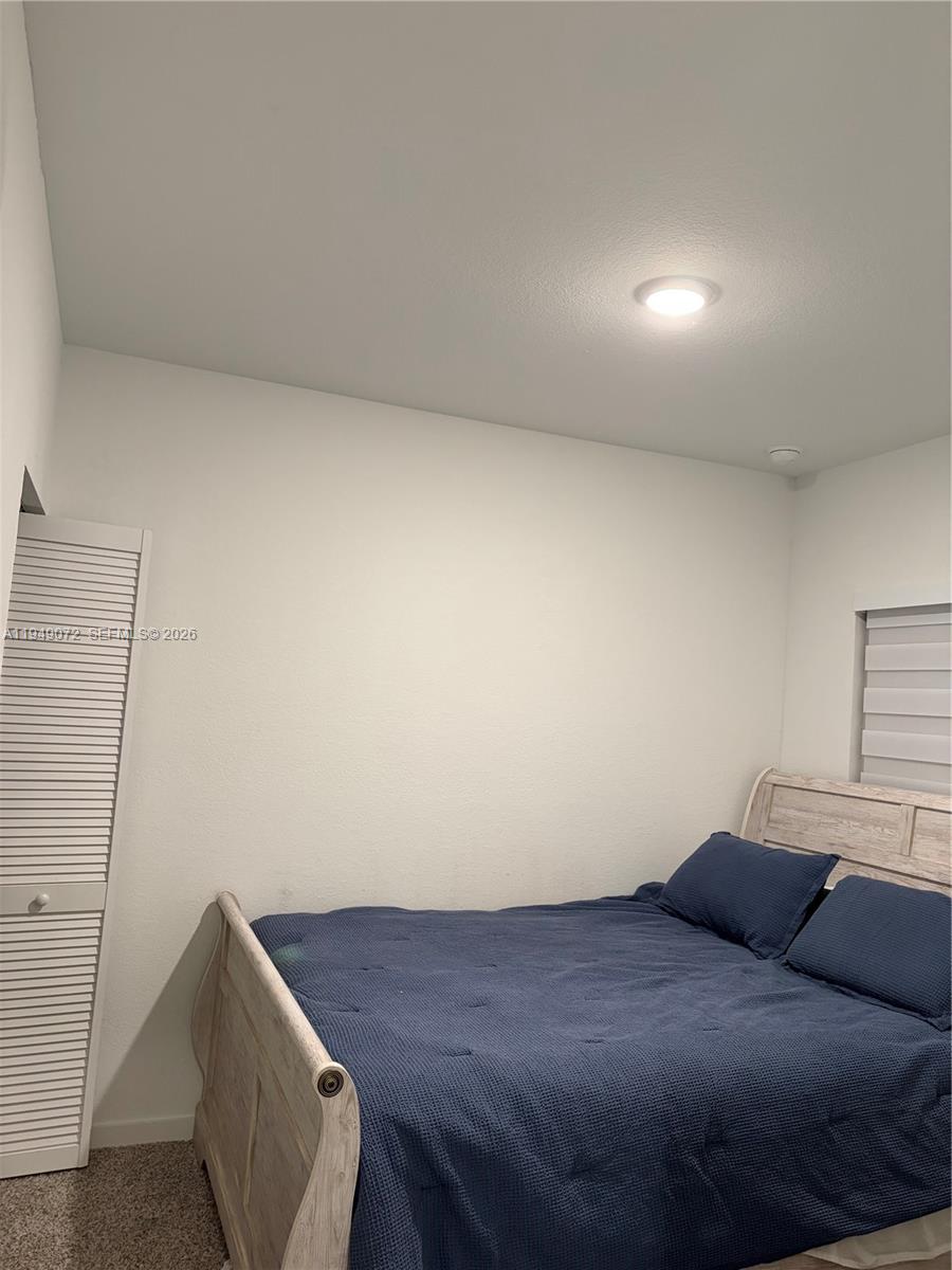 26126 Southwest 146th Avenue, Unit B Homestead, FL 33033 - Photo 2 of 7 a bedroom with a bed and a cabinets