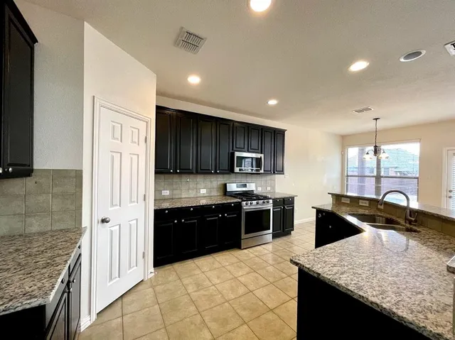 a large kitchen with granite countertop lots of counter top space