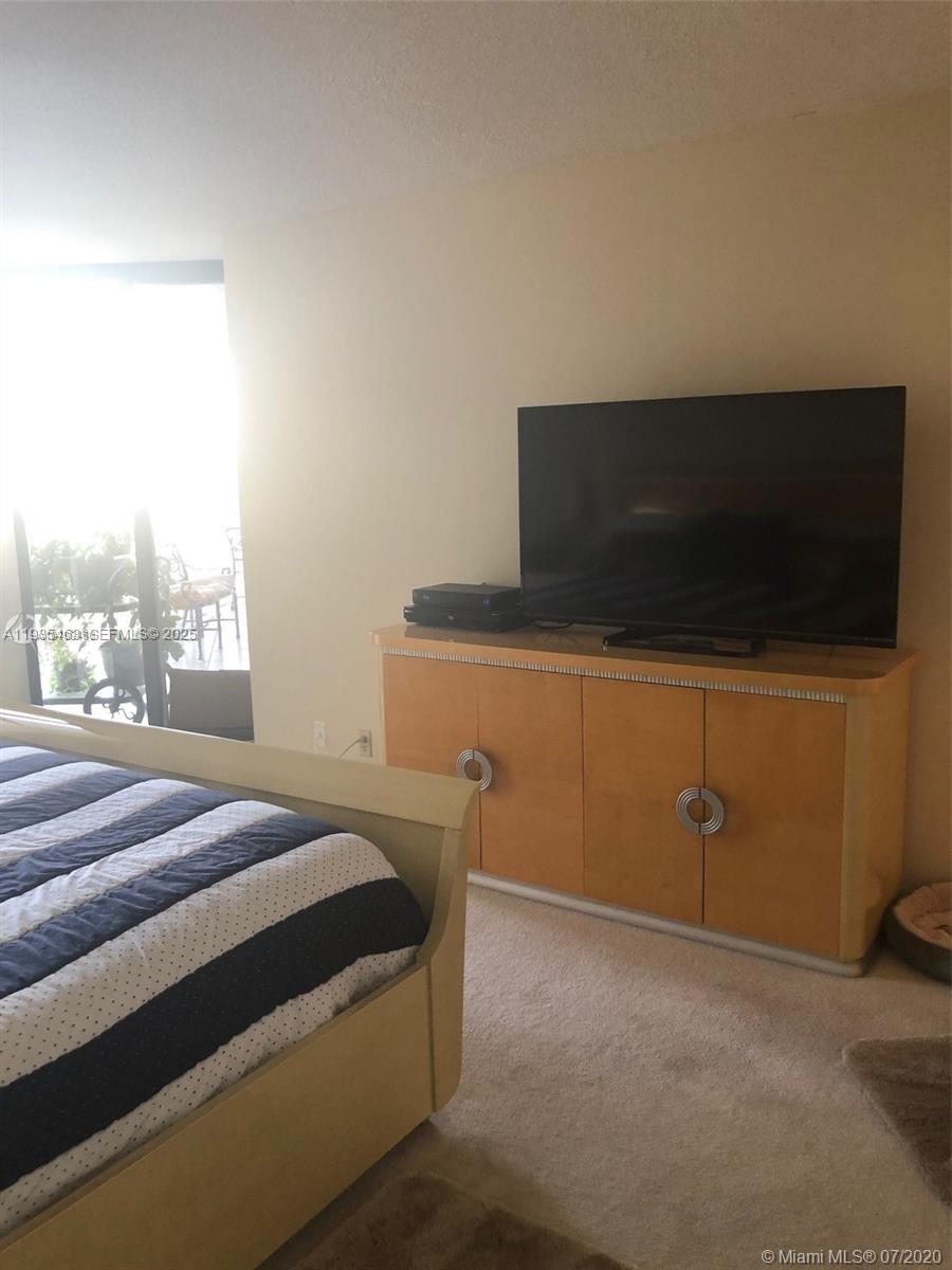 2000 Towerside Terrace, Unit 905 Miami, FL 33138 - Photo 12 of 24 a bedroom with a bed and a flat screen tv