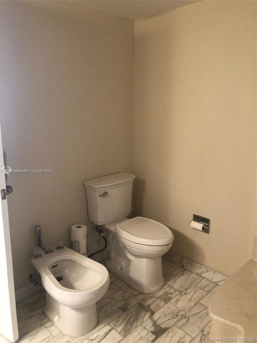 2000 Towerside Terrace, Unit 905 Miami, FL 33138 - Photo 14 of 24 a white toilet sitting next to a white wall