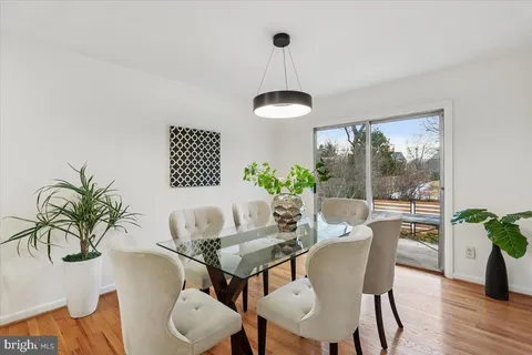 a dining room with furniture potted plants and wooden floor