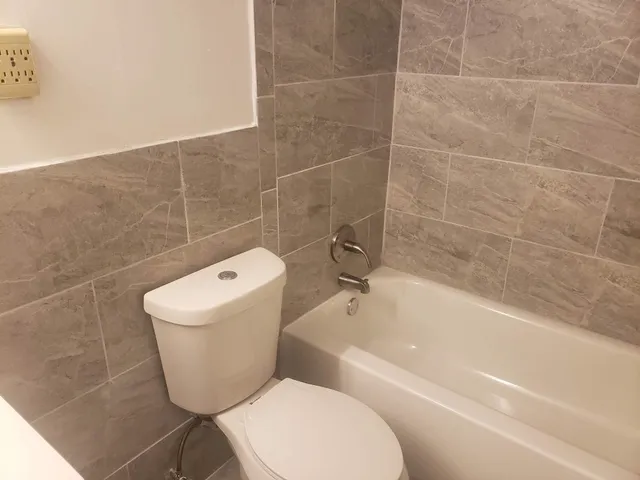 a bathroom with a toilet and bathtub