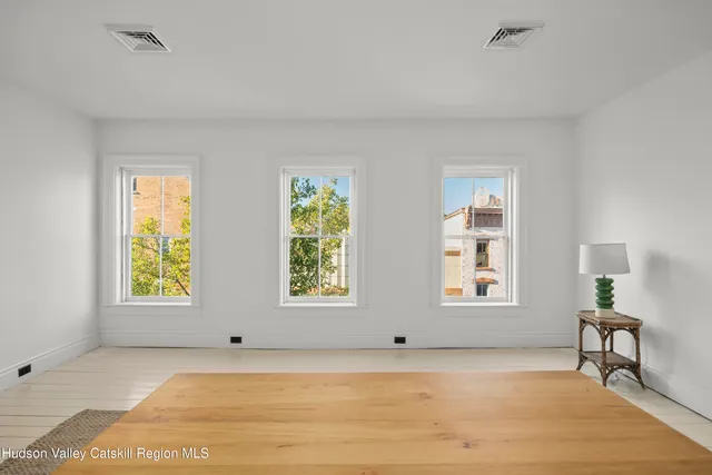 a view of a bedroom with wooden floor and windows