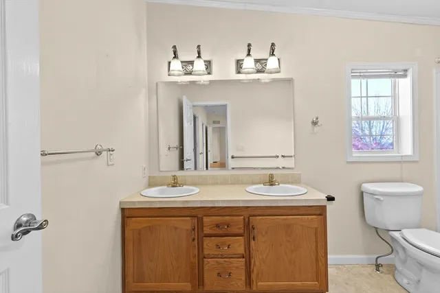 a bathroom with a sink a toilet and a mirror