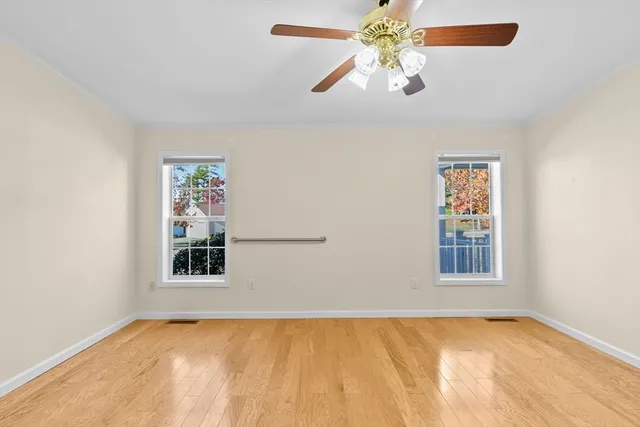 an empty room with windows and fan
