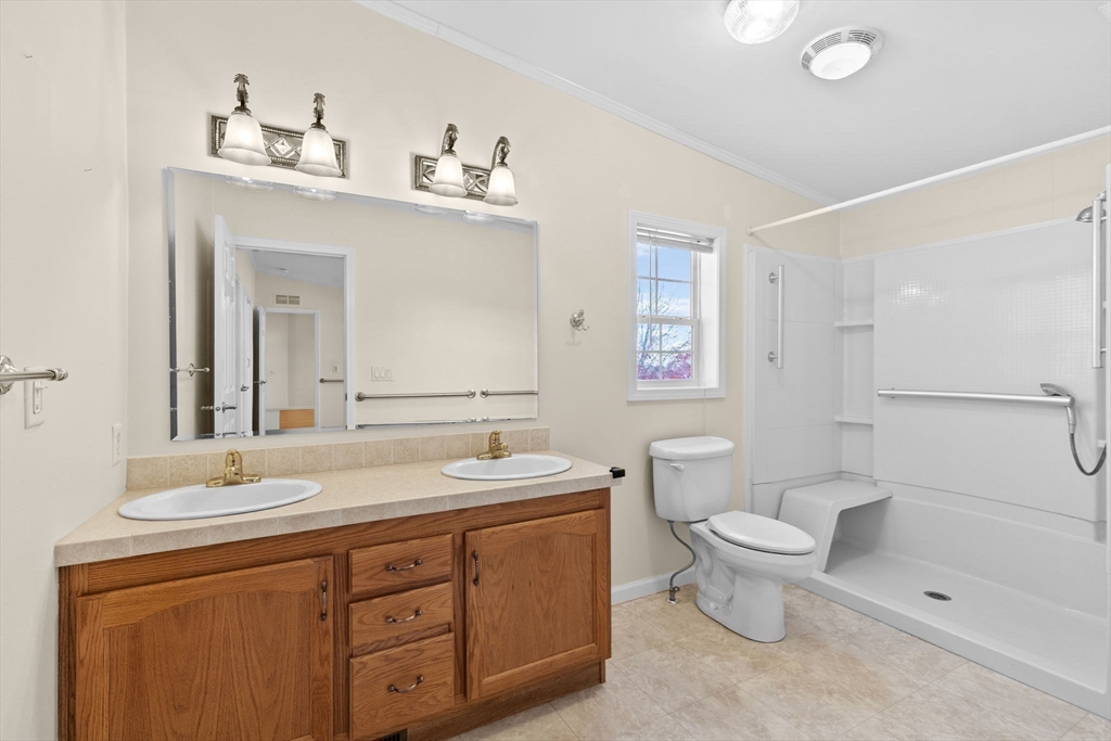 2602 Pheasant Lane Middleboro, MA 02346 - Photo 22 of 40 a bathroom with a double vanity sink a toilet and a mirror
