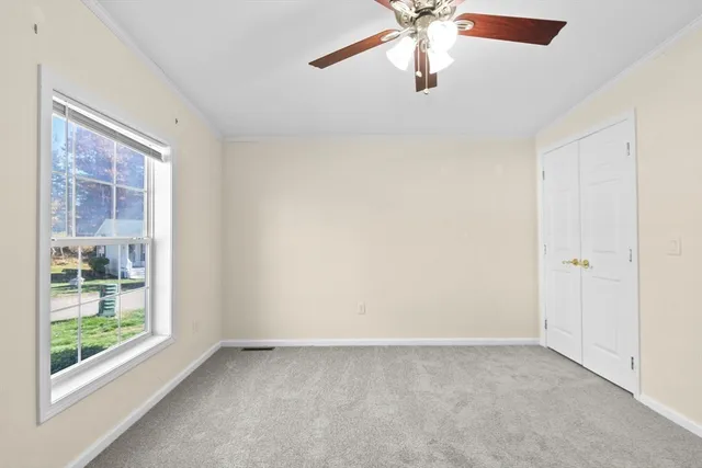 en empty room with windows and ceiling fan