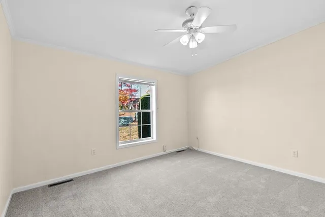 an empty room with windows and ceiling fan