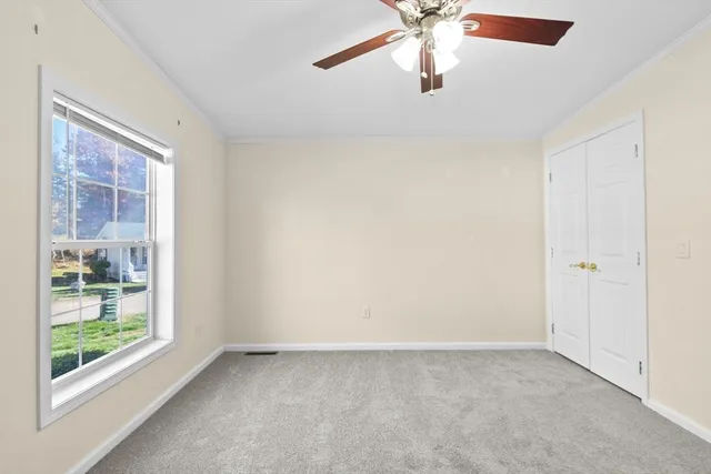 en empty room with windows and ceiling fan