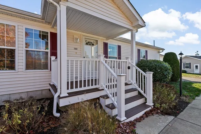 a view of a house with wooden deck and furniture