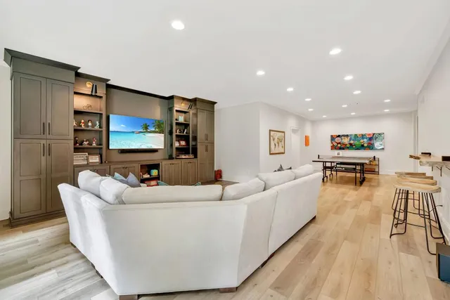 a kitchen with stainless steel appliances granite countertop a stove a sink and white cabinets with wooden floor