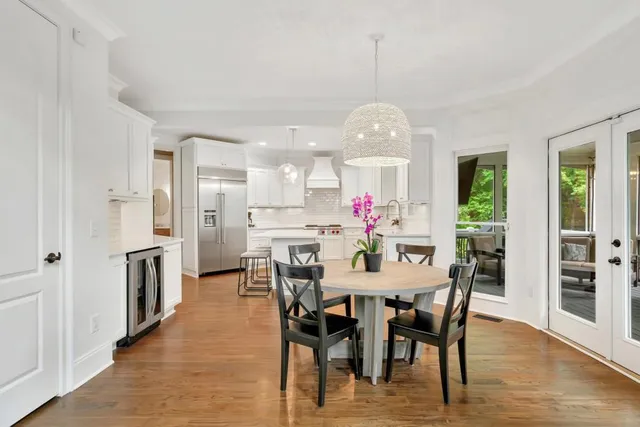 a view of a dining room with furniture a kitchen and chandelier