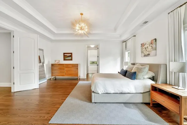 a spacious bedroom with a bed and a chandelier