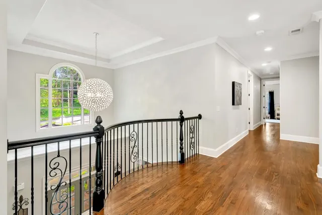 front view of a brick house with a large window plants and palm trees