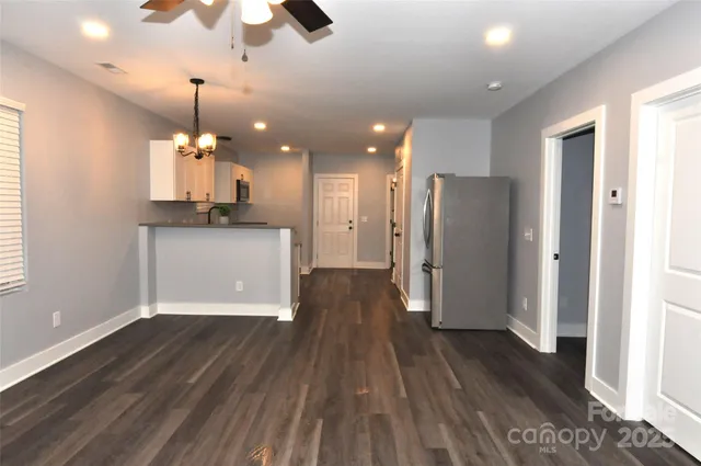a view of a kitchen with a refrigerator wooden floor and a window