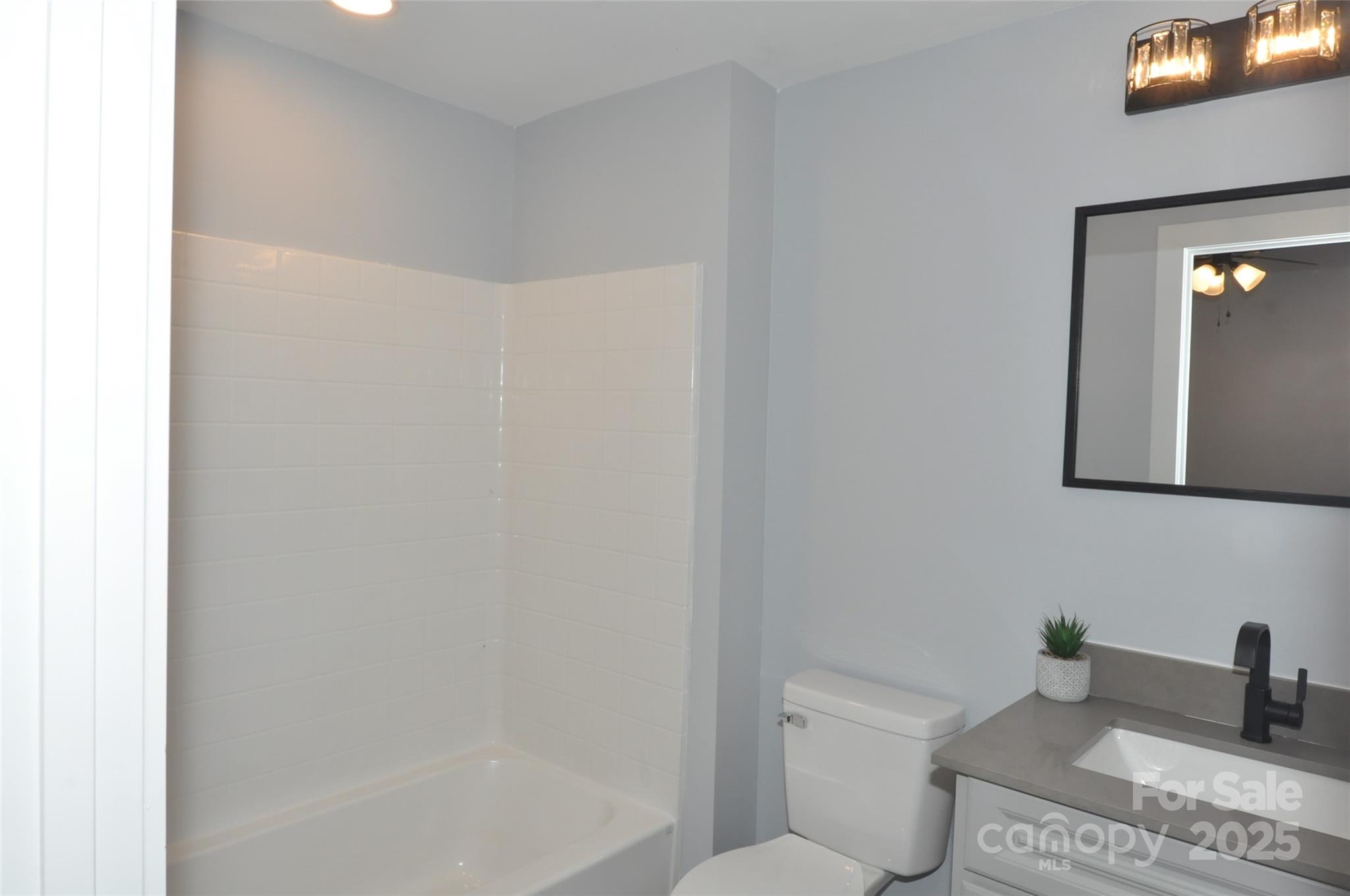560 2nd Street, Unit 16 Chester, SC 29706 - Photo 23 of 25 a bathroom with a granite countertop sink mirror vanity and toilet