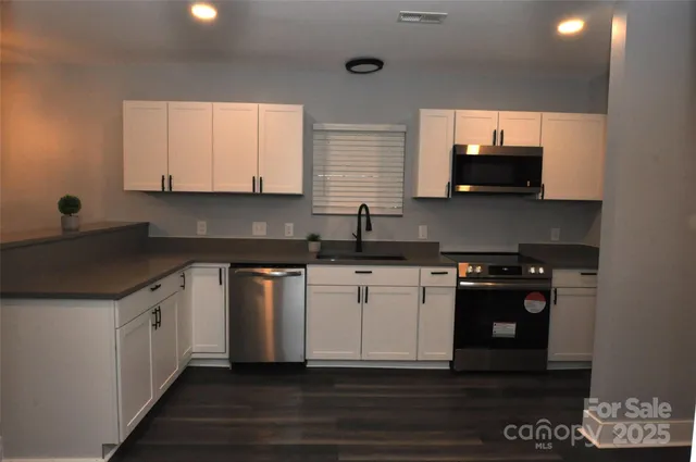 a kitchen with stainless steel appliances granite countertop a stove and a sink