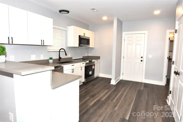 a kitchen with wooden floors and white appliances