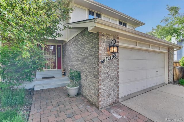 a front view of a house with potted plants