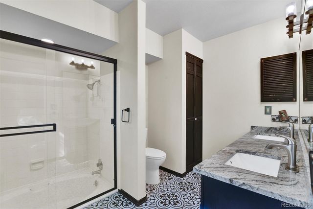 a bathroom with a granite countertop sink toilet and shower