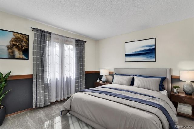 a bedroom with a large bed and a painting on the wall