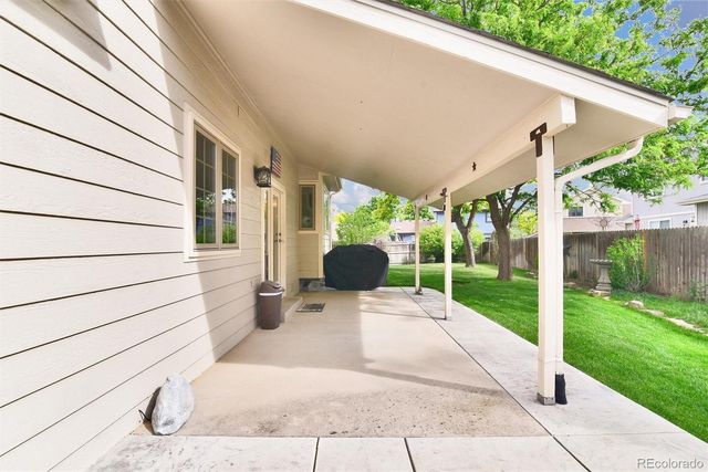 a view of a patio with table and chairs potted plants with wooden floor and fence