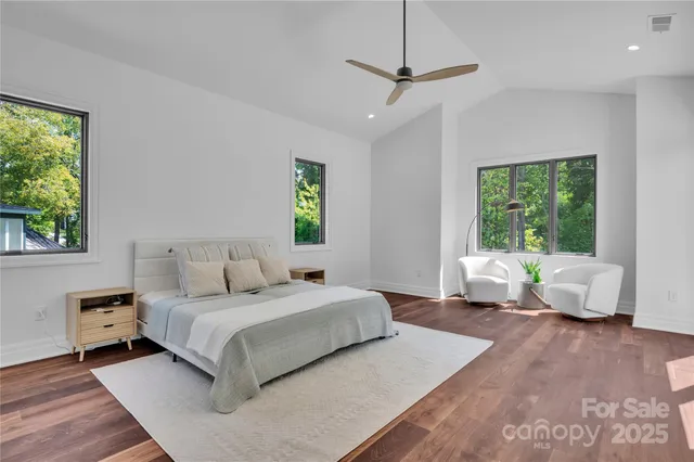 a bedroom with a bed couch and a large window