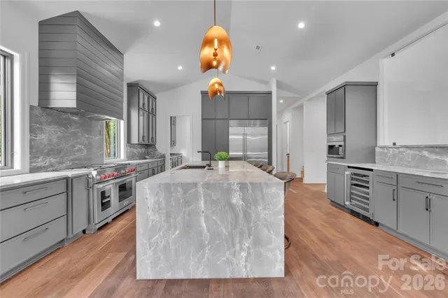 a large kitchen with stainless steel appliances granite countertop a stove and a sink