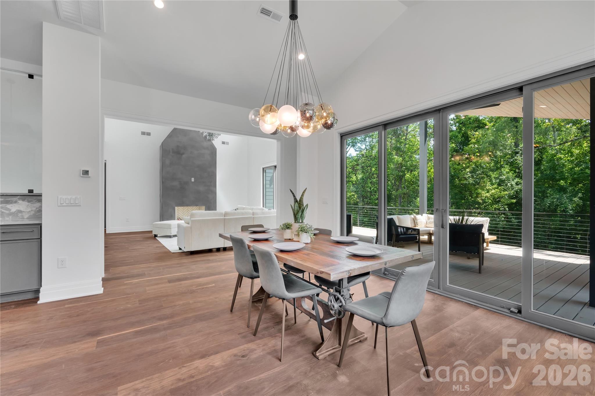 1423 South Wendover Road Charlotte, NC 28211 - Photo 7 of 31 a dining room with wooden floor a chandelier a glass table and chairs
