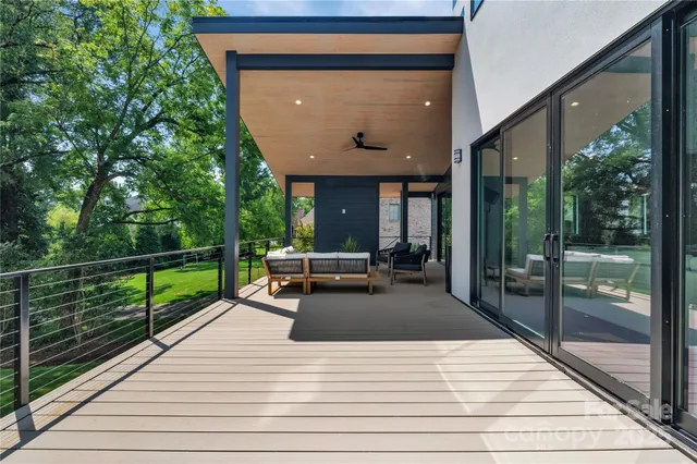 a view of a patio with table and chairs with wooden floor and fence