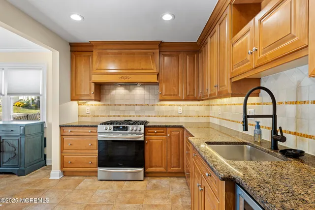 a kitchen with granite countertop a stove a sink and a microwave