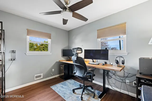a view of a workspace with furniture and a window