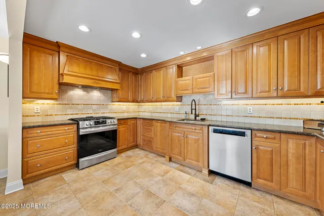 a kitchen with stainless steel appliances granite countertop a stove sink and cabinets