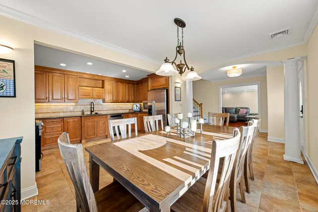 a view of a dining room and livingroom with furniture wooden floor a chandelier