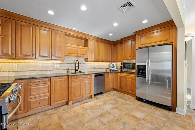a kitchen with granite countertop a sink stainless steel appliances and counter space