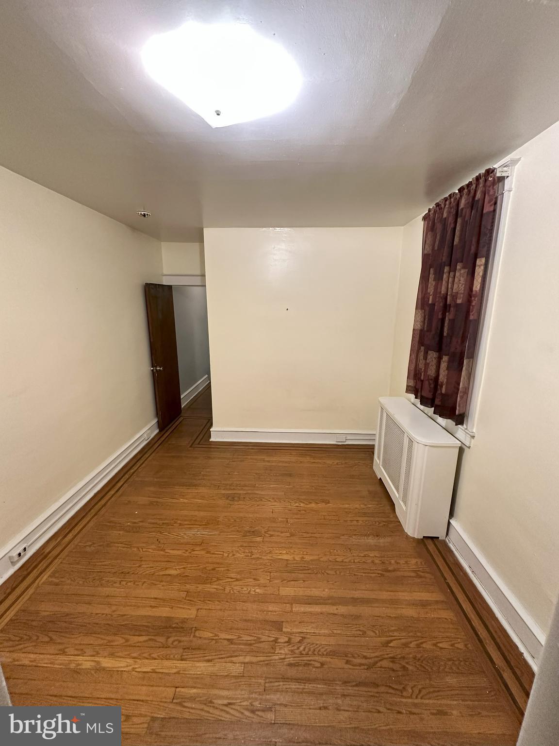 1126 Sanger Street Philadelphia, PA 19124 - Photo 14 of 21 a view of an empty room with wooden floor and a window