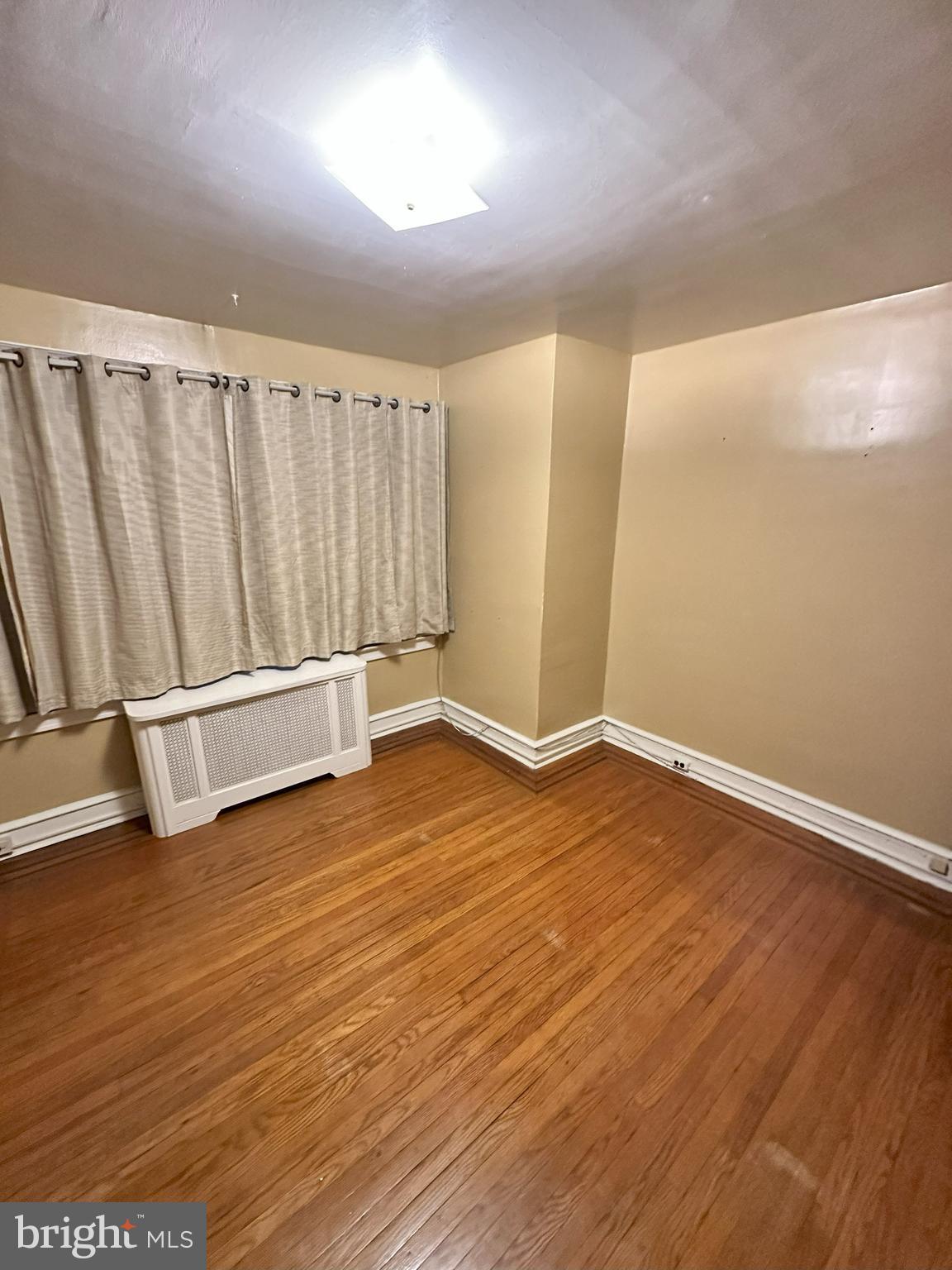 1126 Sanger Street Philadelphia, PA 19124 - Photo 16 of 21 an empty room with wooden floor and windows