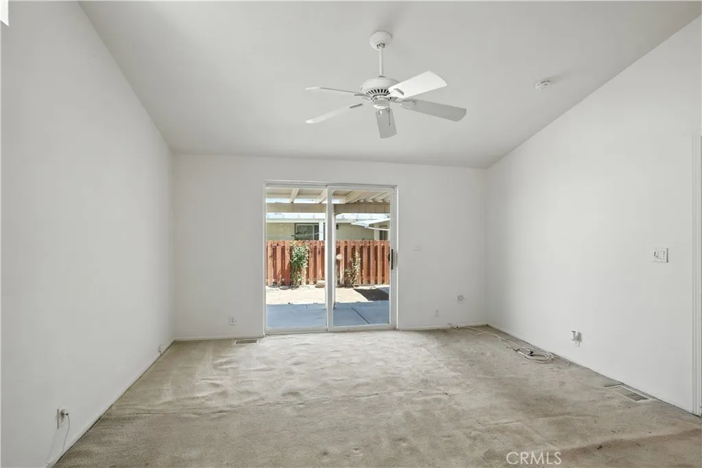 27250 Murrieta Road, Unit 216 Menifee, CA 92586 - Photo 22 of 58 an empty room with chandelier fan and windows