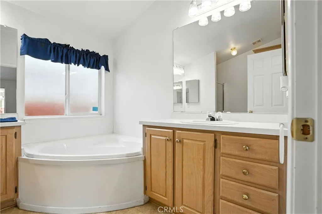 27250 Murrieta Road, Unit 216 Menifee, CA 92586 - Photo 25 of 58 a bathroom with a bathtub a sink and a mirror