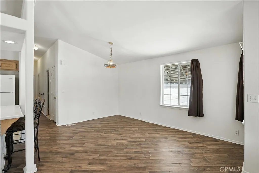 27250 Murrieta Road, Unit 216 Menifee, CA 92586 - Photo 9 of 58 a view of an empty room with wooden floor and a window