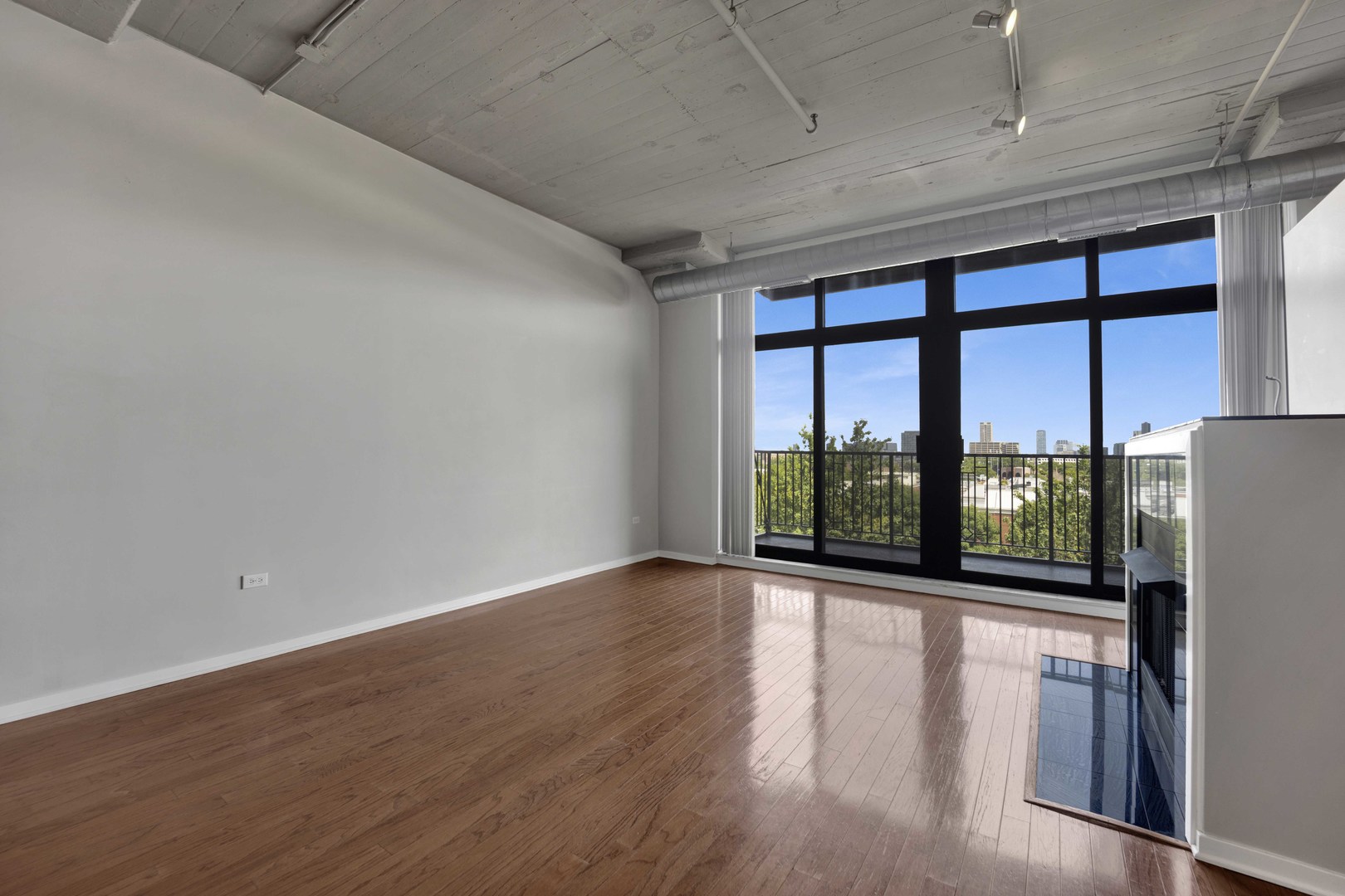 1525 South Sangamon Street, Unit 504 Chicago, IL 60608 - Photo 7 of 32 a view of an empty room with wooden floor and a window