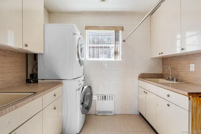 a utility room with cabinets washer and dryer