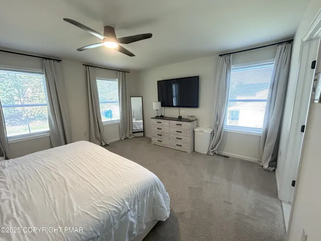 a bedroom with a bed and a flat screen tv on the dresser