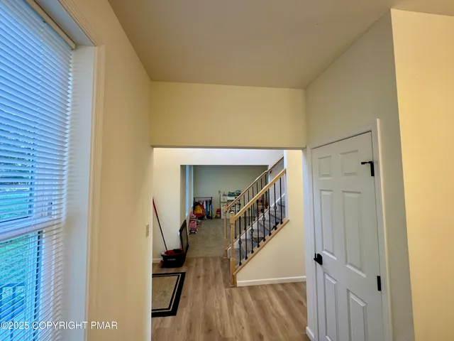 a view of a hallway with wooden floor and staircase
